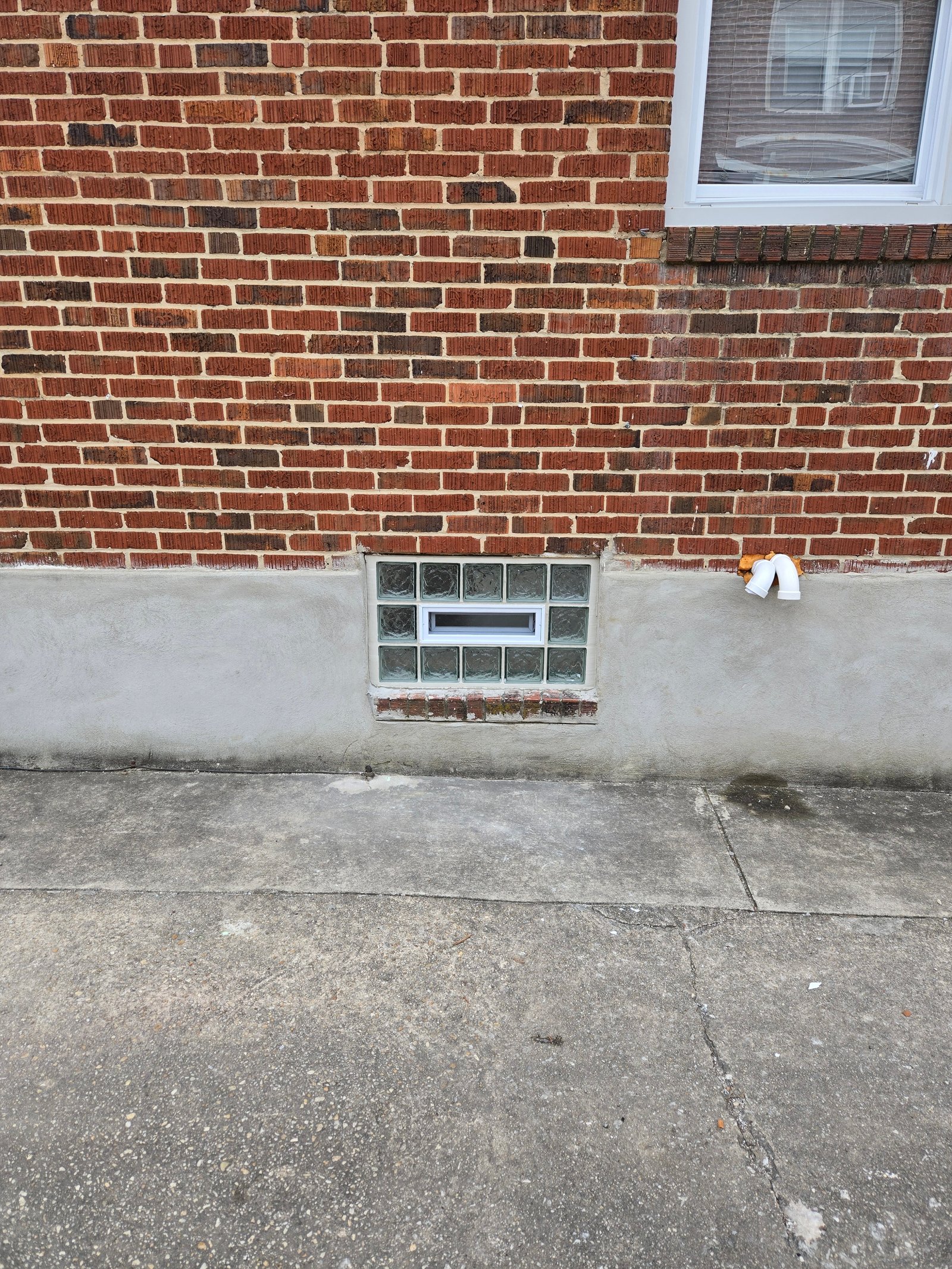 Glass block window with vent in brick wall